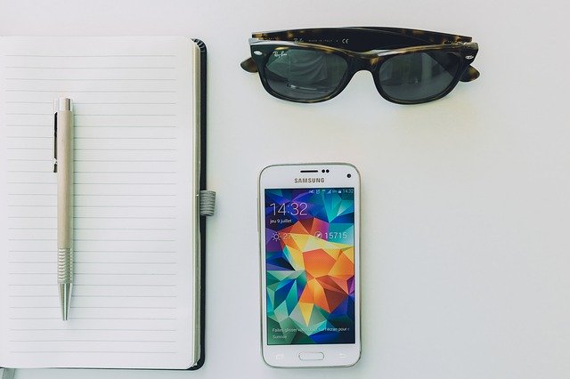Decorative image of planner, sunglasses and mobile