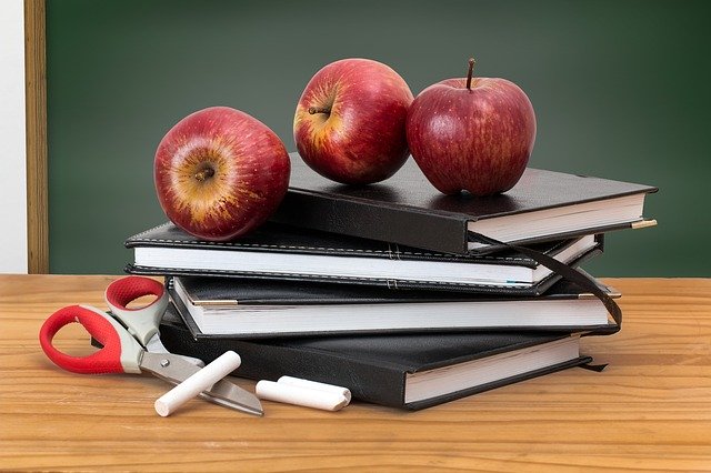 decorative images of apples on notebooks in front of a blackboard